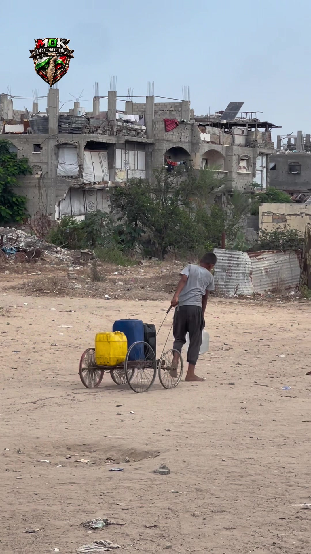 Image de la publication MDK : un enfant transporte des bidons d’eau dans un quartier de Gaza